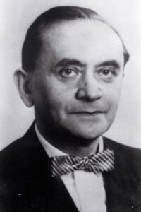 Black-and-white portrait photo of Rabbi Weinberg. Middle-aged man with short hair. Wearing a suit and bow tie. width='300' height='300'